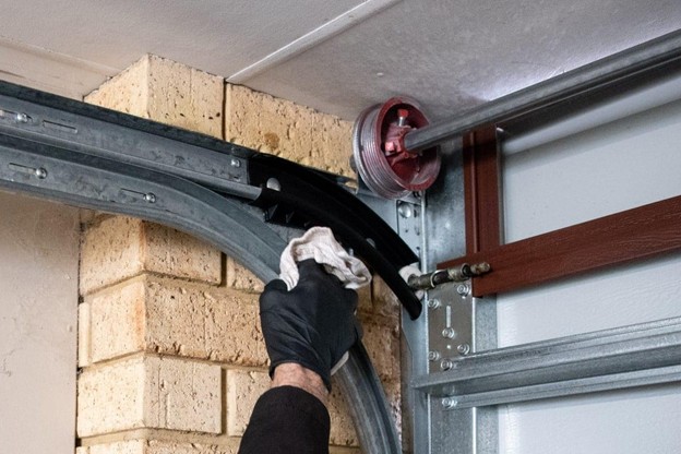 someone wiping down garage door tracks